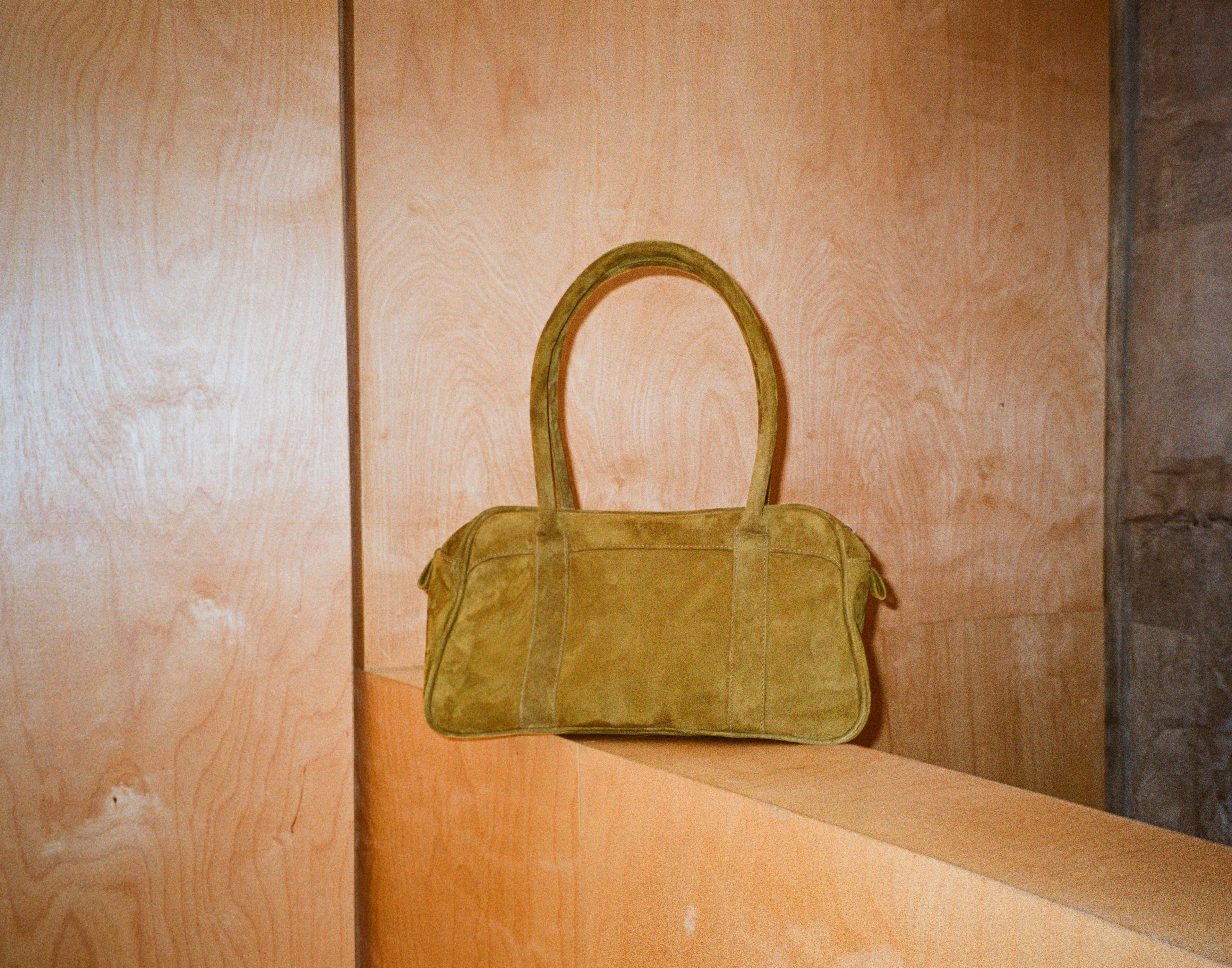 Green handbag on a wooden surface